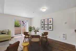 Vancouver townhouse for rent - A dining room with a table set for four and a couch with a pillow.