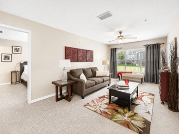 Orlando apartment for rent - A living room with a grey couch, a coffee table, and a rug with a flower design.