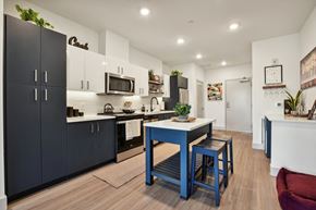 Sacramento apartment for rent - a kitchen with black cabinets and a blue table