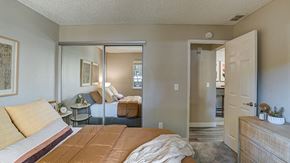 Hayward apartment for rent - Apartments in Hayward for Rent - Austin Commons - Bedroom with Mirrored Closet, Bed, and Dresser.