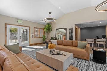 Reno apartment for rent - A living room with a brown leather couch and a wooden coffee table.