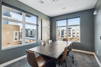 A conference room with a large table and chairs.