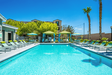 Las Vegas apartment for rent - A large swimming pool with lounge chairs and umbrellas.
