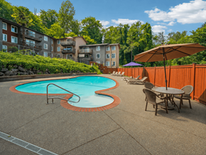 Seattle apartment for rent - A pool surrounded by a concrete patio and chairs.
