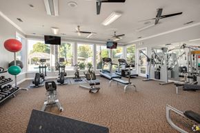 Sacramento apartment for rent - a gym with cardio machines and other exercise equipment and windows