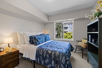 Everett apartment for rent - A bedroom with a bed and a window showing a view of a building.