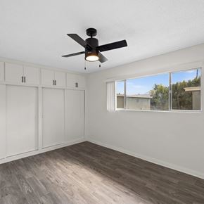 Sherman Oaks apartment for rent - A room with a ceiling fan and a window overlooking a residential area.