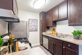 Cypress apartment for rent - A kitchen with brown cabinets and a stove top oven.