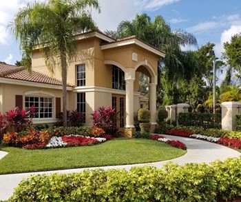 A home with a round driveway and palm trees