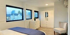 Oakland apartment for rent - A bedroom with a bed, dresser, and chair.
