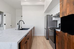Sacramento apartment for rent - a kitchen with marble counter tops and wooden cabinets and a stainless steel refrigerator