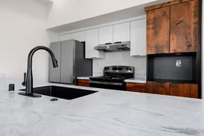 Sacramento apartment for rent - a kitchen with marble counter tops and black appliances