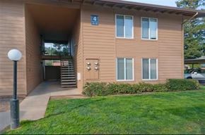 Sacramento apartment for rent - A brown building with a blue sign on the front.