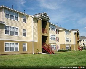 Orlando apartment for rent - A row of apartment buildings with a red staircase leading to the entrance.