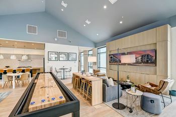 A common room with a shuffleboard table and couches
