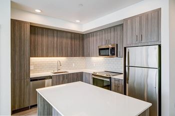 The kitchen in a bedroom plus den unit.
