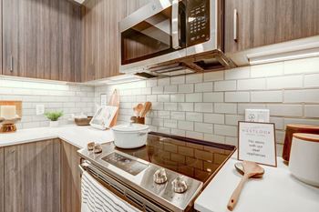 A kitchen with a stove top oven next to a microwave