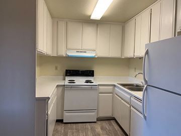 Ramona apartment for rent - A kitchen with white cabinets and appliances.