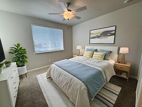 Sacramento apartment for rent - A bedroom with a bed, nightstand, and a ceiling fan at Cottages at Laguna, Sacramento, CA