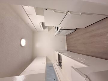 Miramar apartment for rent - A white kitchen with a stove top oven and a sink.