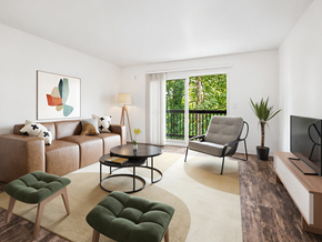 Seattle apartment for rent - A living room with a brown couch, a green ottoman, a coffee table, and a television.