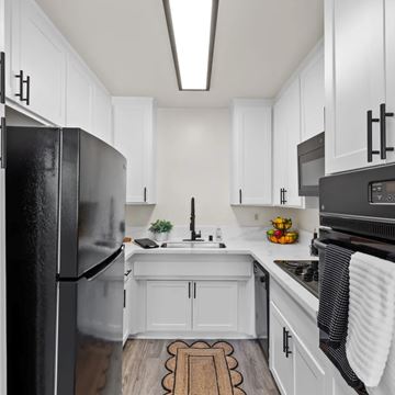 Sherman Oaks apartment for rent - A kitchen with white cabinets and a black refrigerator.
