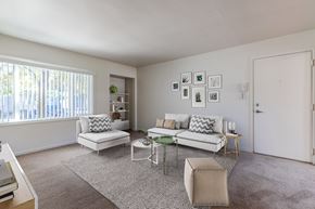 Seattle apartment for rent - A living room with a white couch, a green coffee table, and a rug at Lake Washington Apartments, Seattle, WA