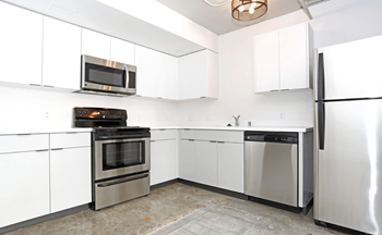 A kitchen with white cabinets and stainless steel appliances.