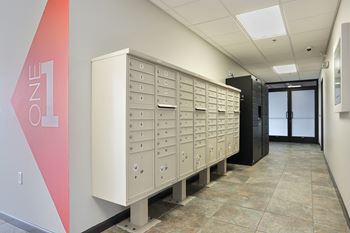 A row of mailboxes are lined up in a hallway.