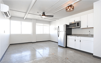 A spacious kitchen with white cabinets and a stainless steel refrigerator.