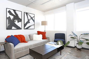 Reno apartment for rent - A living room with a grey couch, a coffee table, and two abstract black and white paintings on the wall.