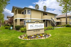 Santa Rosa apartment for rent - the apartments sign in front of grass and flowers at THE MEADOWS, Santa Rosa, CA, 95404