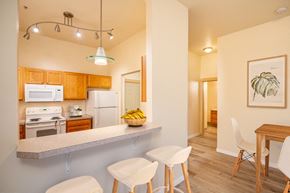 Fairview apartment for rent - A kitchen with a counter and chairs. at Fairview Village Apartments, Fairview, OR, 97024