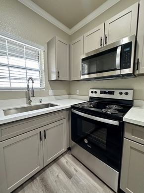 Rancho Cordova apartment for rent - a kitchen with white cabinets and a black stove and microwave