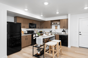 Shoreline apartment for rent - a kitchen with black appliances and a white table with two stools at QUINN BY VINTAGE, Shoreline, Washington