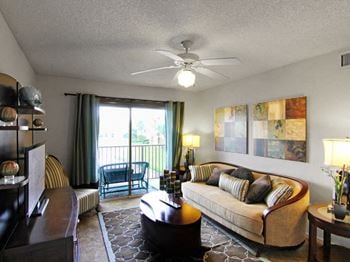 San marco apartment home living area with balcony and ceiling fan with lots of natural lighting