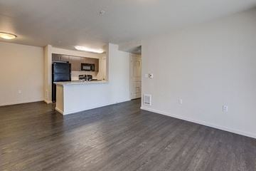 Puyallup apartment for rent - A spacious living room with a television and a kitchenette in the background.