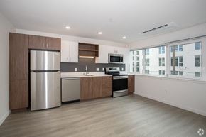 Sacramento apartment for rent - Midtown Sacramento, CA Apartments - Mod at Midtown - Modern Kitchen with Stainless Steel Appliances, Two-Tone Cabinetry, Quartz Countertops, Induction Cooktop, Plank Wood Flooring, and Wall to Wall Windows