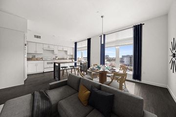 South San Francisco apartment for rent - A modern living room with a grey couch and a dining table.