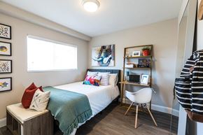 Orem apartment for rent - a bedroom with a bed and a desk with a chair at Mountain Run Apartments, Utah