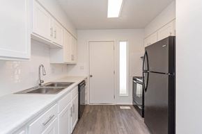 Roy apartment for rent - a kitchen with white cabinets and a black refrigerator at Cadence Apartments, Roy