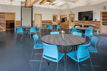 Beaverton apartment for rent - A conference room with a round table surrounded by blue chairs.