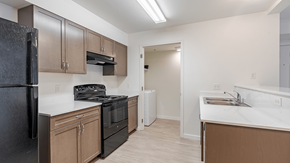 Coeur D'alene apartment for rent - A kitchen with black appliances and brown cabinets at Falls Creek Apartments in Couer d'Alene, Idaho, 83815