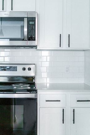 New Braunfels apartment for rent - White kitchen with stainless steel appliances and tile backsplash