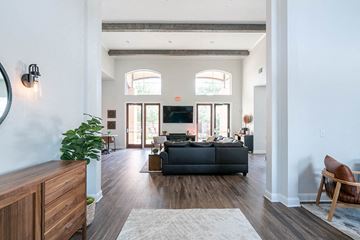 New Braunfels apartment for rent - A living room with a black couch and a wooden chair.