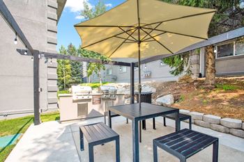 A patio with a table and chairs with an umbrella