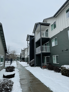 Coeur D'alene apartment for rent - A snow-covered walkway leads to a building with a balcony at Falls Creek Apartments in 83815
