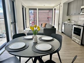 Portland apartment for rent - a kitchen and living room with a table and chairs and a large window at DOCK 59 APARTMENTS, PORTLAND, Oregon
