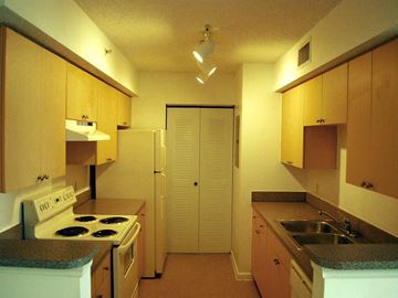 Miami apartment for rent - a kitchen with a stove and sink and a refrigerator