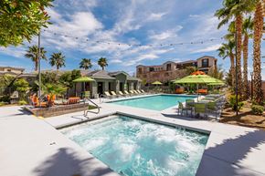 Las Vegas apartment for rent - a swimming pool with chairs and umbrellas and a house in the background at EVERETT APARTMENT HOMES, Nevada
